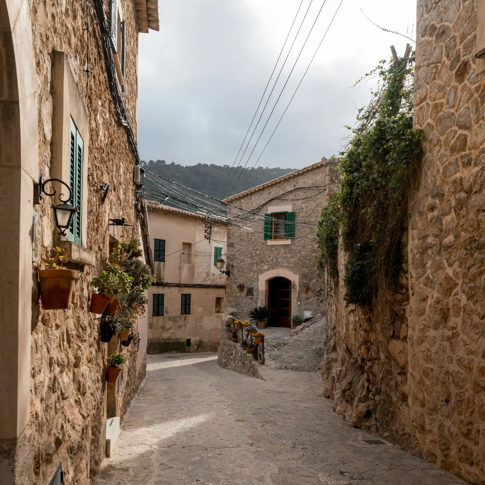 Calle de Mallorca con casas de piedra y contraventanas verdes
